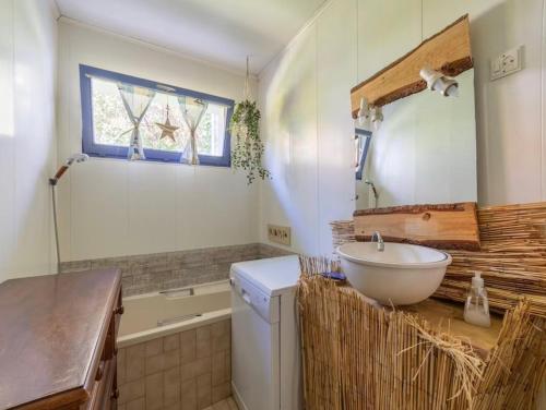 ein Badezimmer mit einem Waschbecken und einem Spiegel auf der Theke in der Unterkunft La Marquisienne avec jardin in Marquise