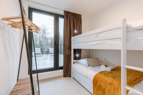 a bedroom with two bunk beds and a balcony at Huswell - Apartment with two large terraces in Zedelgem