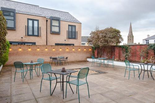 a patio with tables and chairs in front of a building at Bendene Townhouse - Exeter in Exeter