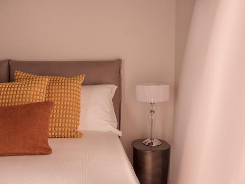 a bedroom with a bed with a lamp and pillows at B&B CCAA Ascona in Ascona