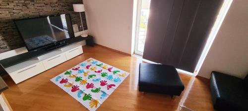 a living room with a television and a rug at Zaprešić apartmani i sobe in Zaprešić