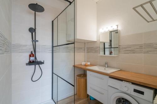 une salle de bain avec une machine à laver et un lavabo dans l'établissement Le Lacydon - proche MUCEM, à Marseille