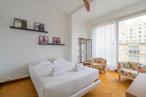 ein weißes Schlafzimmer mit einem Bett und einem Fenster in der Unterkunft Le Lacydon - proche MUCEM in Marseille