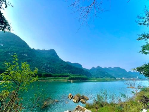 a view of a lake with mountains in the background at Little Rock Homestay in Phong Nha