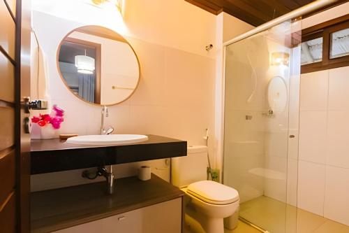 uma casa de banho com um lavatório, um WC e um espelho. em Bangalô da Barra, chalé 20 - BG em Barra Grande