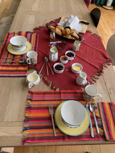 a table with plates and utensils on a table at Flint House, Rew Lane, Chichester in Lavant