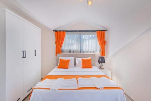 a white bedroom with an orange and white bed at Villa Simge 4+1 Ölüdeniz in Fethiye