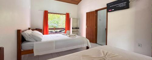 two beds in a room with a window and a mirror at Pousada J Country in Sana