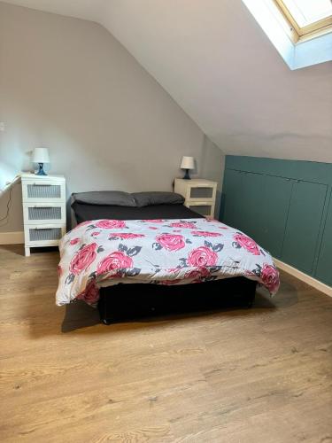a bedroom with a bed with a floral bedspread at Nice and Pleasant in Thornton Heath