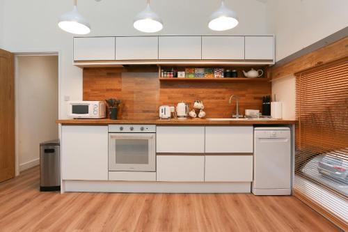 a kitchen with white cabinets and a stove top oven at Strawberry Line, Apartment 2 in Wells