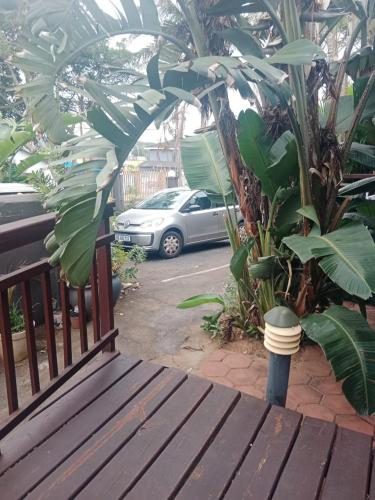 a wooden bench sitting in front of a parking lot at Bayview Guest House in Amanzimtoti