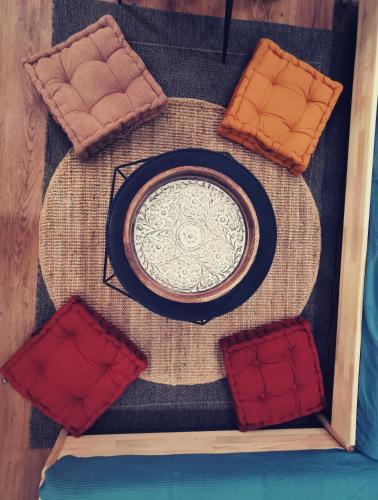 - une table avec une assiette et quelques oreillers rouges dans l'établissement La Discretion by Connexion, à Cannes