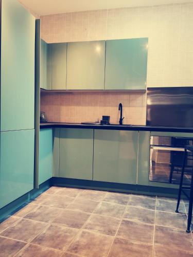 Il comprend une cuisine avec des placards bleus et du carrelage. dans l'établissement La Discretion by Connexion, à Cannes