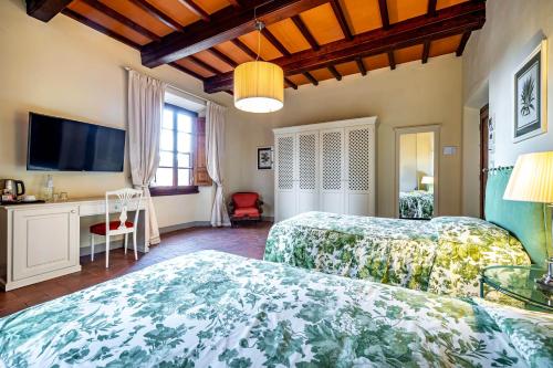 a bedroom with two beds and a flat screen tv at Villa S.Andrea in San Casciano in Val di Pesa