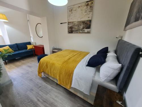 倫敦的住宿－Stratford Prime Rooms，一间卧室配有一张床和一张蓝色的沙发