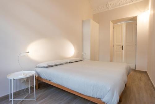 ein weißes Schlafzimmer mit einem Bett und einem Tisch in der Unterkunft Centro città - Comodo per visitare la città in Turin