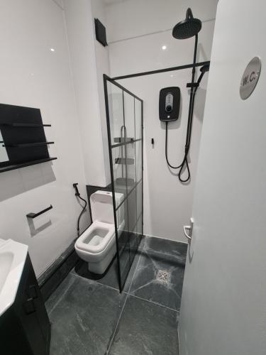 a bathroom with a toilet and a shower in it at Stratford Prime Rooms in London