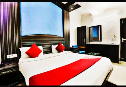 Hotel Global Stay Near Delhi Airport في نيودلهي: غرفة نوم بسرير كبير ومخدات حمراء
