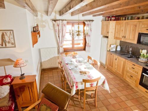 une salle à manger avec une table et une cuisine dans l'établissement Duplex 3 Pièces avec Jardin Privatif, Wifi et Parking à Serre Chevalier - FR-1-762-17, à Saint-Chaffrey