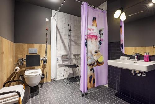 Baño con cabeza de jirafa en la cortina de la ducha en Moxy Simmern en Simmern