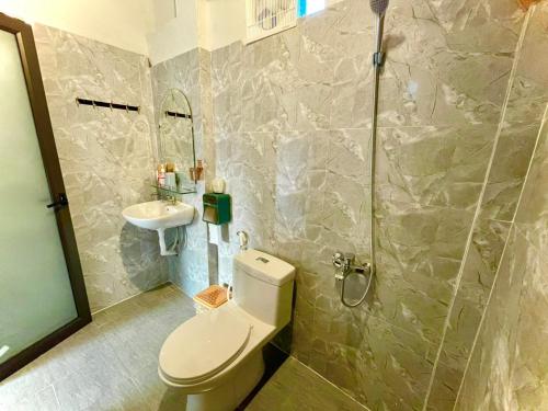La salle de bains est pourvue de toilettes et d'un lavabo. dans l'établissement Little Rock Homestay, à Phong Nha