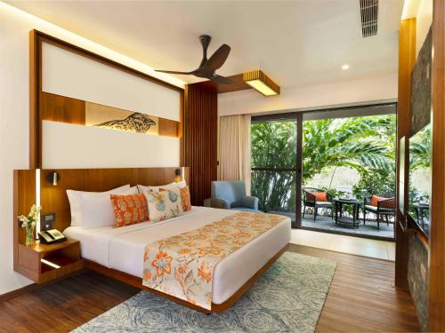 a bedroom with a large bed and a balcony at Scenic, Munnar - IHCL SeleQtions in Munnar