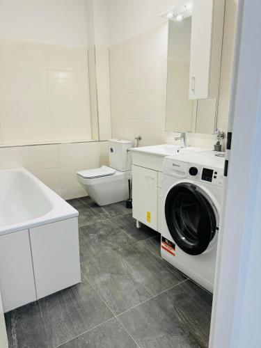 uma casa de banho com uma máquina de lavar roupa e um WC em Private Zimmervermietung Felix em Trebbin