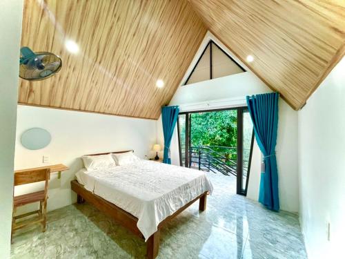 - une chambre avec un lit et un plafond en bois dans l'établissement Little Rock Homestay, à Phong Nha