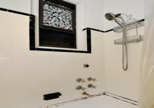 uma casa de banho com um chuveiro e uma janela em Designer 2BD 1BA In Upper East side em Nova York