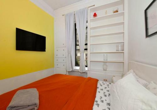 um quarto com uma cama e uma televisão na parede em Designer 2BD 1BA In Upper East side em Nova York