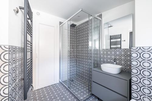 une salle de bain avec un lavabo et une douche dans l'établissement Le Bréa, Élégant appartement, jolie vue mer, à Menton
