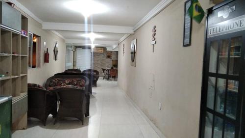 a hallway with chairs and tables in a store at Pousada Villa Goyá in São José da Coroa Grande