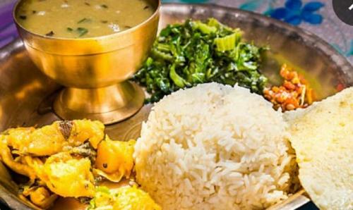 un plato con arroz y verduras y un tazón de sopa en SHIVAY Guest House en Deoghar