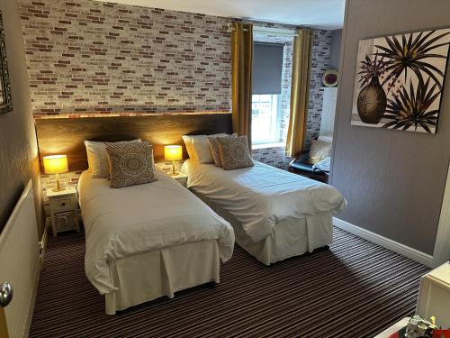 een hotelkamer met 2 bedden en 2 lampen bij The Cricketers Arms in Barnard Castle