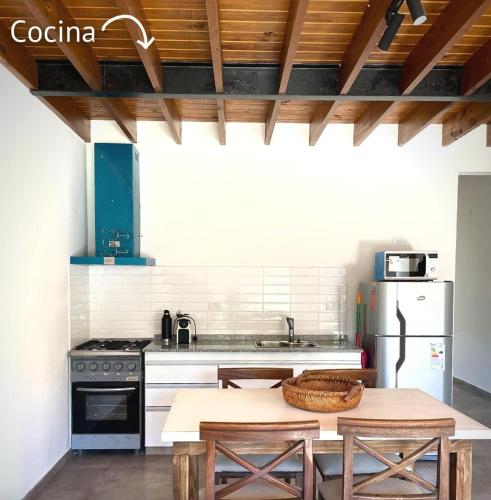 a kitchen with a table and a refrigerator at Departamento los cardales in Los Cardales