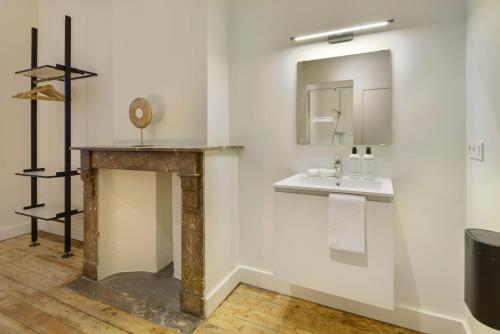 a bathroom with a sink and a mirror at The 1894 Residence by Domani Hotels in Antwerp