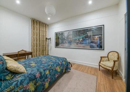 una camera da letto con un letto e una sedia e un grande dipinto sul muro di SYDNEY a Montargis