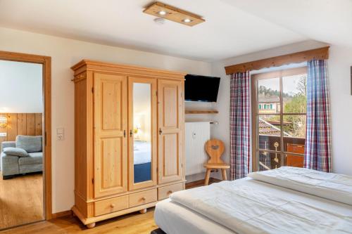 Un dormitorio con un gran armario de madera y una cama en Haus Alpenquelle Alpenblick, en Bad Kohlgrub