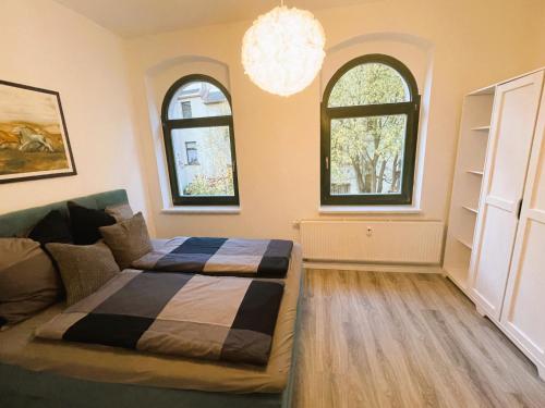 a bedroom with a bed and two windows at 59m² Ferienwohnung "Max" - direkt an der Erlebniswelt & Skiarena bis 4 Personen in Eibenstock