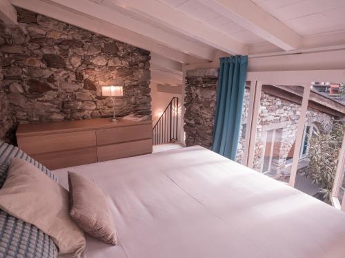 a bedroom with a bed and a stone wall at B&B CCAA Ascona in Ascona