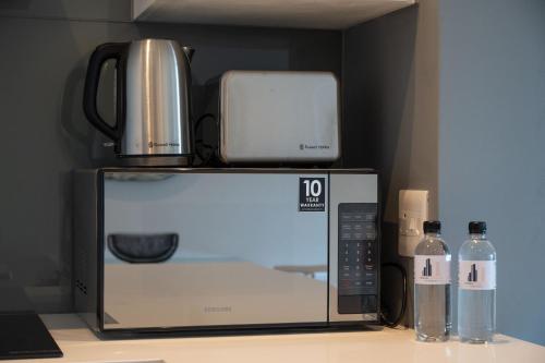 a microwave with a coffee maker on top of it at Oceans Umhlanga Accommodation in Durban