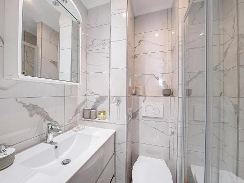 uma casa de banho branca com um lavatório e um chuveiro em Nestor&Jeeves - SUITE FLORA - Promenade des Anglais - Central em Nice