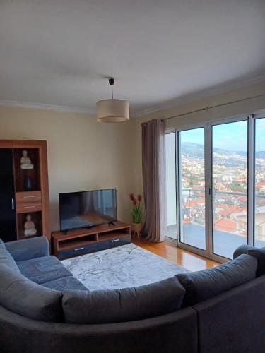 a living room with a couch and a flat screen tv at Ocean Paradise Til II in Funchal