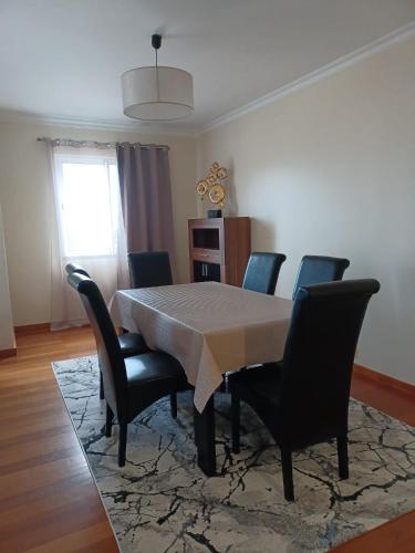 a dining room with a table and chairs and a window at Ocean Paradise Til II in Funchal