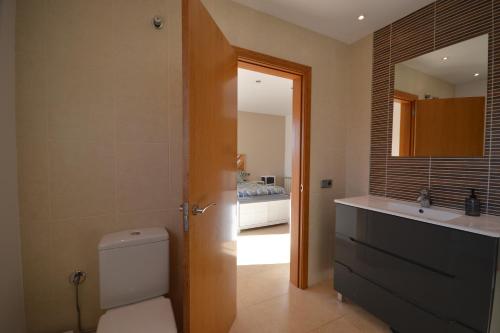 uma casa de banho com um WC, um lavatório e uma cama em Villa Naira em Calonge