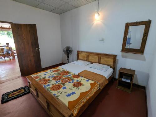 1 dormitorio con cama y espejo en DILSHAN HOTEL Diyaluma, en Koslanda