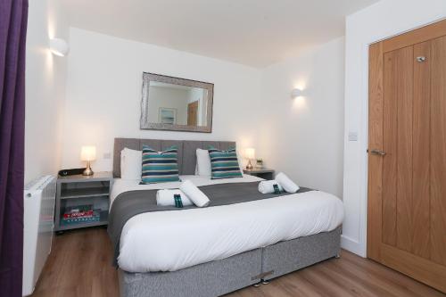 a bedroom with a large bed with blue and white pillows at Strawberry Line, Apartment 2 in Wells