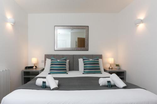 a bedroom with a large bed with blue and white pillows at Strawberry Line, Apartment 2 in Wells