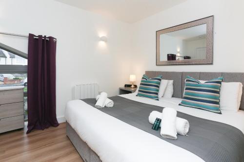 a bedroom with a large bed with blue and white pillows at Strawberry Line, Apartment 2 in Wells