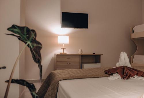 a bedroom with a bed and a tv on the wall at Vicoletto Fiorito in Porto Empedocle